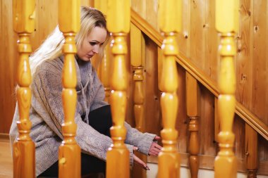 Merdivende oturan süveterli genç bir kız. 