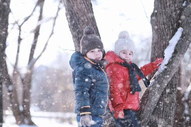Çocuklar parkta kuşları besler. 