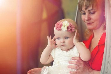 Bebek kız kollarında. Anne çocuğunu onun kollarında tutar. Küçük bir bebek ile mutlu anne