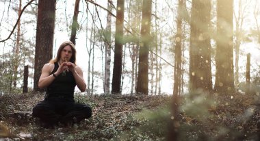 Doğada bir araçla bir müzisyen. Bir adam bir flüt çalıyor bir 