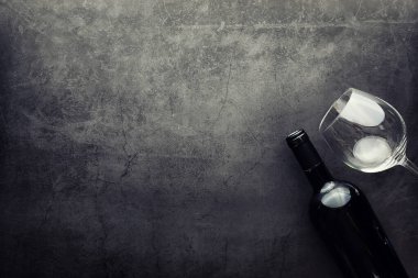 Şarap kadehi ve siyah şarap şişesi. Ceviz peyniri ve domates.