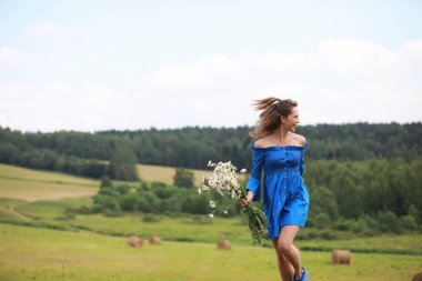 Genç tatlı kız bir alanda gün batımında koşmak