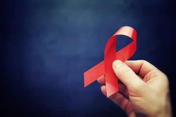 Symbol of human immunodeficiency virus disease. Red ribbon. A he