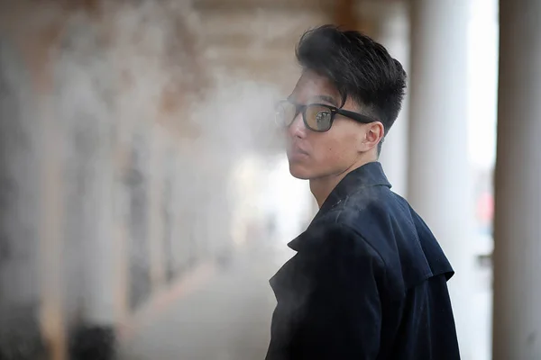 Asiatique jeune homme fumant dans la rue — Photo