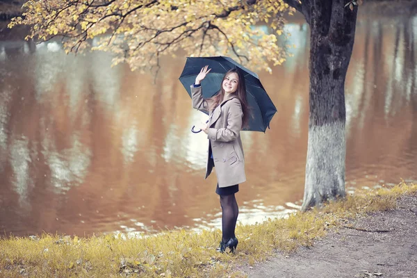 Outono tempo chuvoso e um jovem com um guarda-chuva — Fotografia de Stock