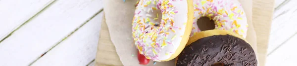 Horizontale bakground van chocolade donuts op een tafel — Stockfoto