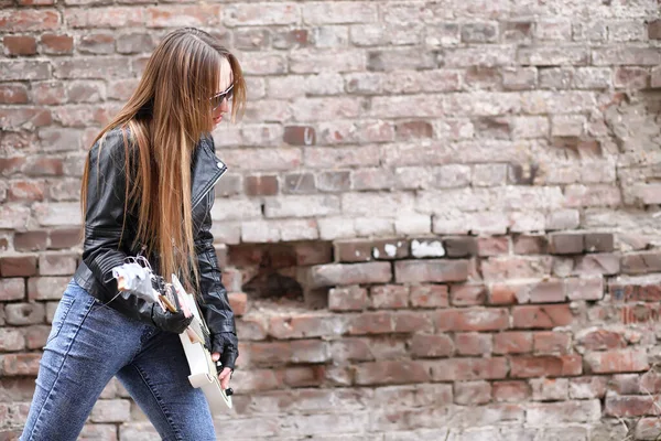 Une musicienne rock dans une veste en cuir avec une guitare — Photo