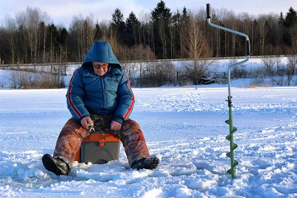 Anciano pescando en el invierno en el lago — Foto de Stock