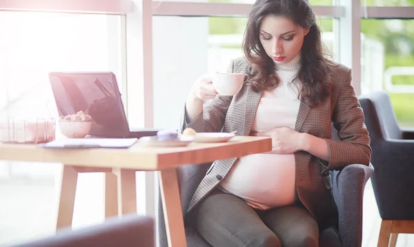 妊娠中の女性がカフェ内のコンピューターでの作業 — ストック写真