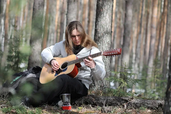 Guitarrista na floresta num piquenique. Um músico com um acústico — Fotografia de Stock