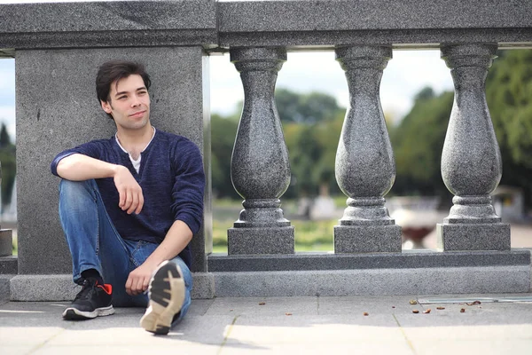 A young man walks in the park at lunch time. A man is on a walk