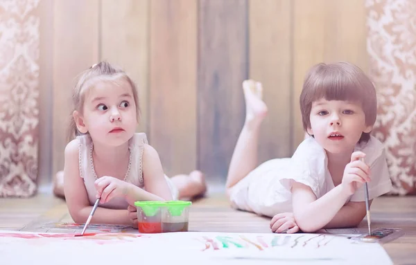 Petits enfants peignent sur une grande feuille de papier — Photo