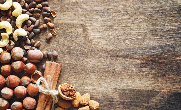 Olika nötter på ett träbord. Ceder, cashew, hasselnöt, walnu — Stockfoto