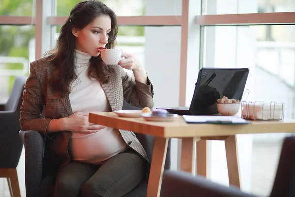 Zwangere vrouw die werkt op computer in café — Stockfoto