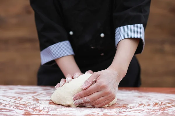 De kok maakt meel voor het bakken op tafel — Stockfoto