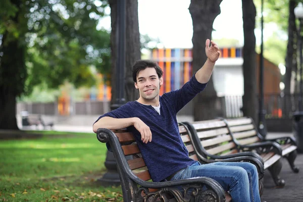 A young man walks in the park at lunch time. A man is on a walk