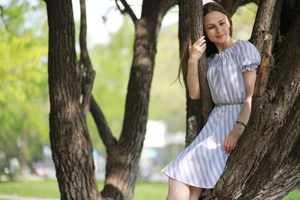 Uma menina em um parque verde primavera — Fotografia de Stock