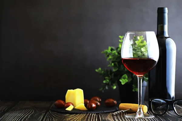 Una copa de vino tinto seco sobre la mesa. Botella oscura y vidrio de w — Foto de Stock