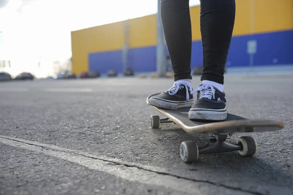 A young hipster girl is riding a skateboard. Girls girlfriends f — Stock Photo, Image