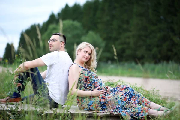 Fille enceinte avec gros ventre et jeune homme en plein air — Photo