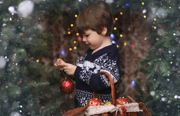 A little child by the New Year tree. Children decorate the Chris — Stock Photo, Image