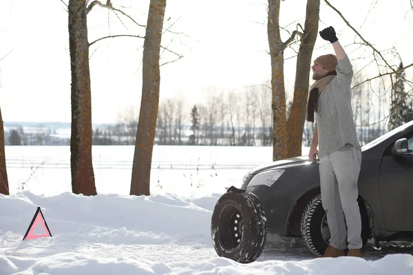 A man near a broken car on a winter day — Stock Photo, Image