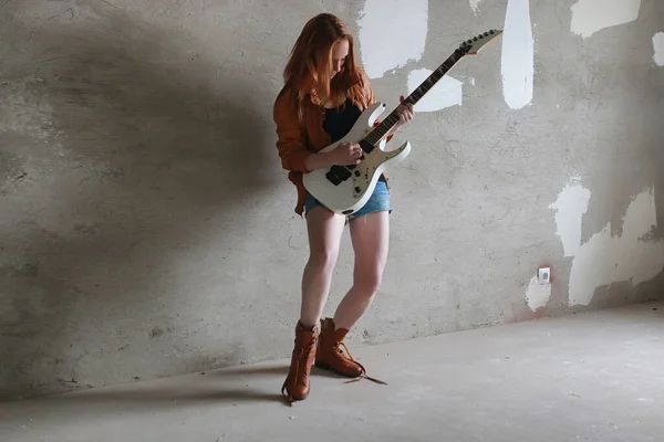 Menina ruiva jovem com uma guitarra elétrica. Músico de rock gir — Fotografia de Stock