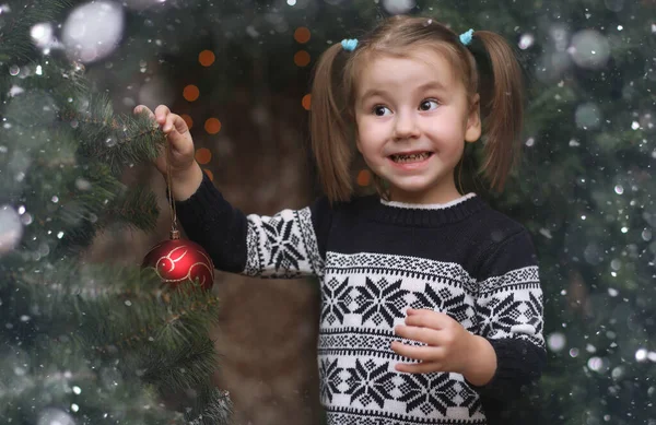 Un niño pequeño junto al árbol de Año Nuevo. Los niños decoran el Chris —  Fotos de Stock