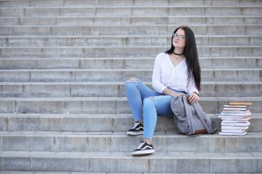 Kız öğrenci kitapları ile sokakta