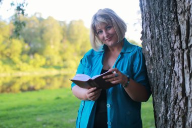 kadınla çimenlerin üzerinde kitapla Park