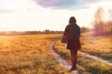 Parkta bir yürüyüş üzerinde şapkalı bir kız. Bir kızla bir sepet yürüyüş