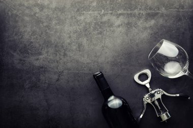 Şarap kadehi ve siyah şarap şişesi. Ceviz peyniri ve domates.