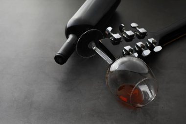 Gitar ve cam bardak. Arka planda kırmızı şarap..