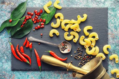 Taş zeminde pişmemiş makarna. Baharat ve baharatlarla