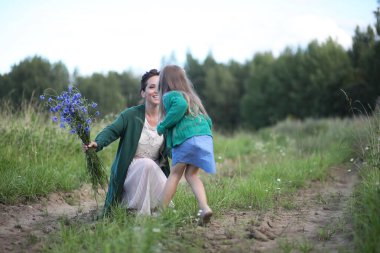 Anne ve kızı yolda yürüyor.