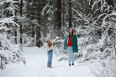 Genç bir aile yürüyüşe çıktı. Anne ve kızı şarapla yürüyorlar.