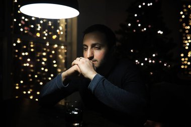 Gece kulübünde elinde buzlu bir bardak alkol tutan bir adam. 