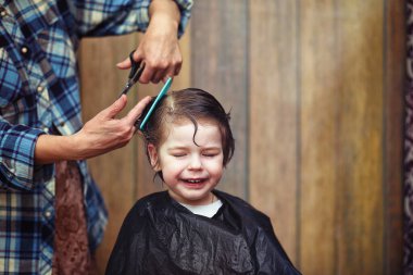 Küçük bir çocuk kuaförde kesilmiş. 