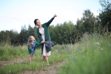 Anne ve kızı yolda yürüyor.