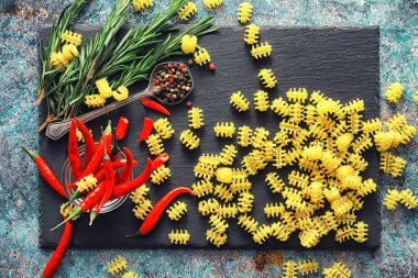 Taş zeminde pişmemiş makarna. Baharat ve baharatlarla