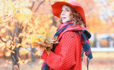 Kız sonbahar şehir parkında yaprak düşer. Genç güzel wi anne