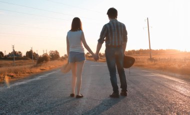 Bir çift genç adam ve bir kız sonbahar parkında yürüyorlar.