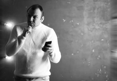 Beyaz kazak giyen bir adam.