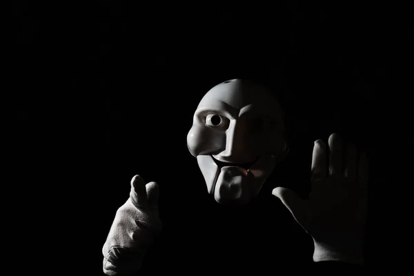 白人の手で黒の背景に白い恐ろしいマスク. — ストック写真