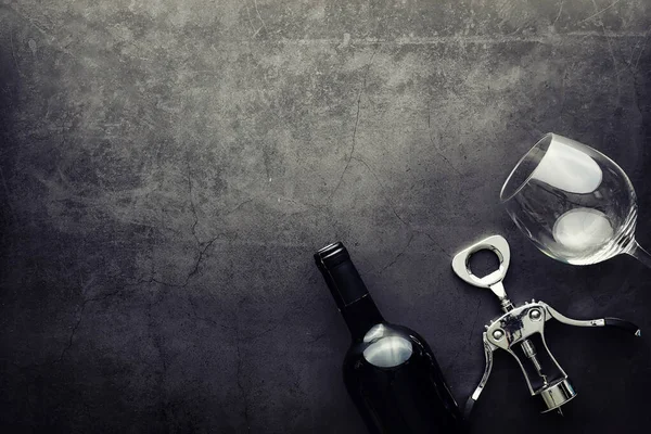 Şarap kadehi ve siyah şarap şişesi. Ceviz peyniri ve domates.