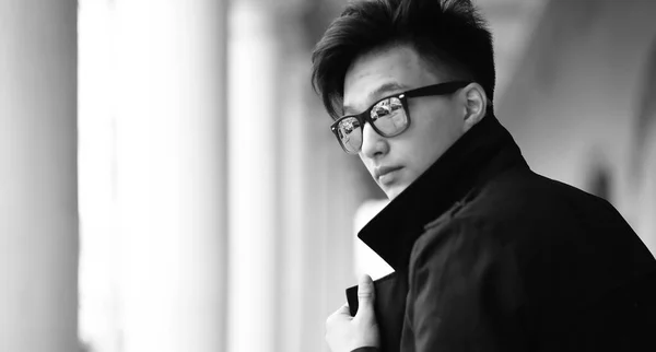 Черно-белое фото азиатского молодого человека, позирующего на улице — стоковое фото