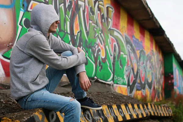 Kapüşonlu hip-hop giyen genç bir adam.