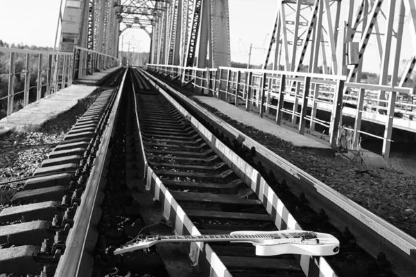 Zwart-wit elektrische gitaar op de railroad tracks en steen — Stockfoto