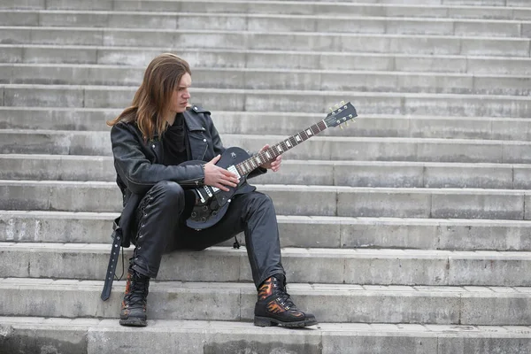 Rockgitarrist på stegen. En musiker med en basgitarr i en — Stockfoto
