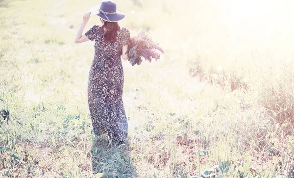 Ragazza incinta in un campo con fiori — Foto Stock